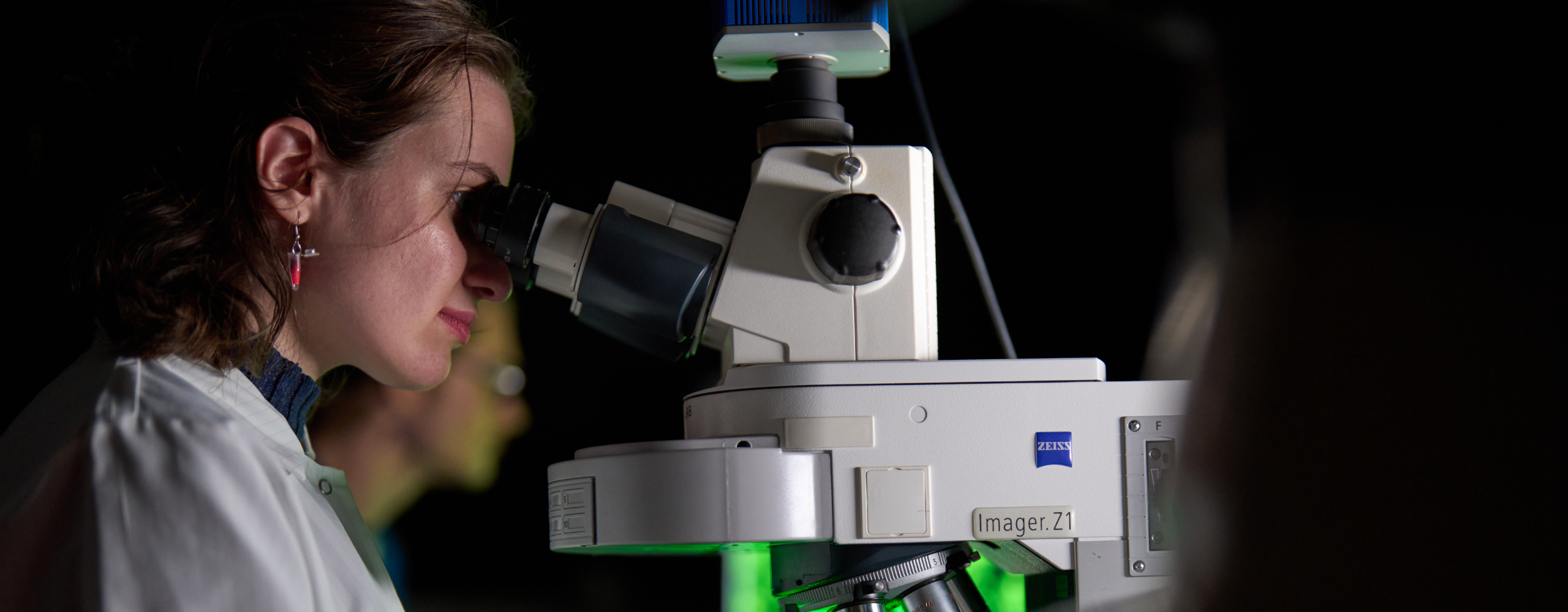 Student in Choksi lab looks through microscope