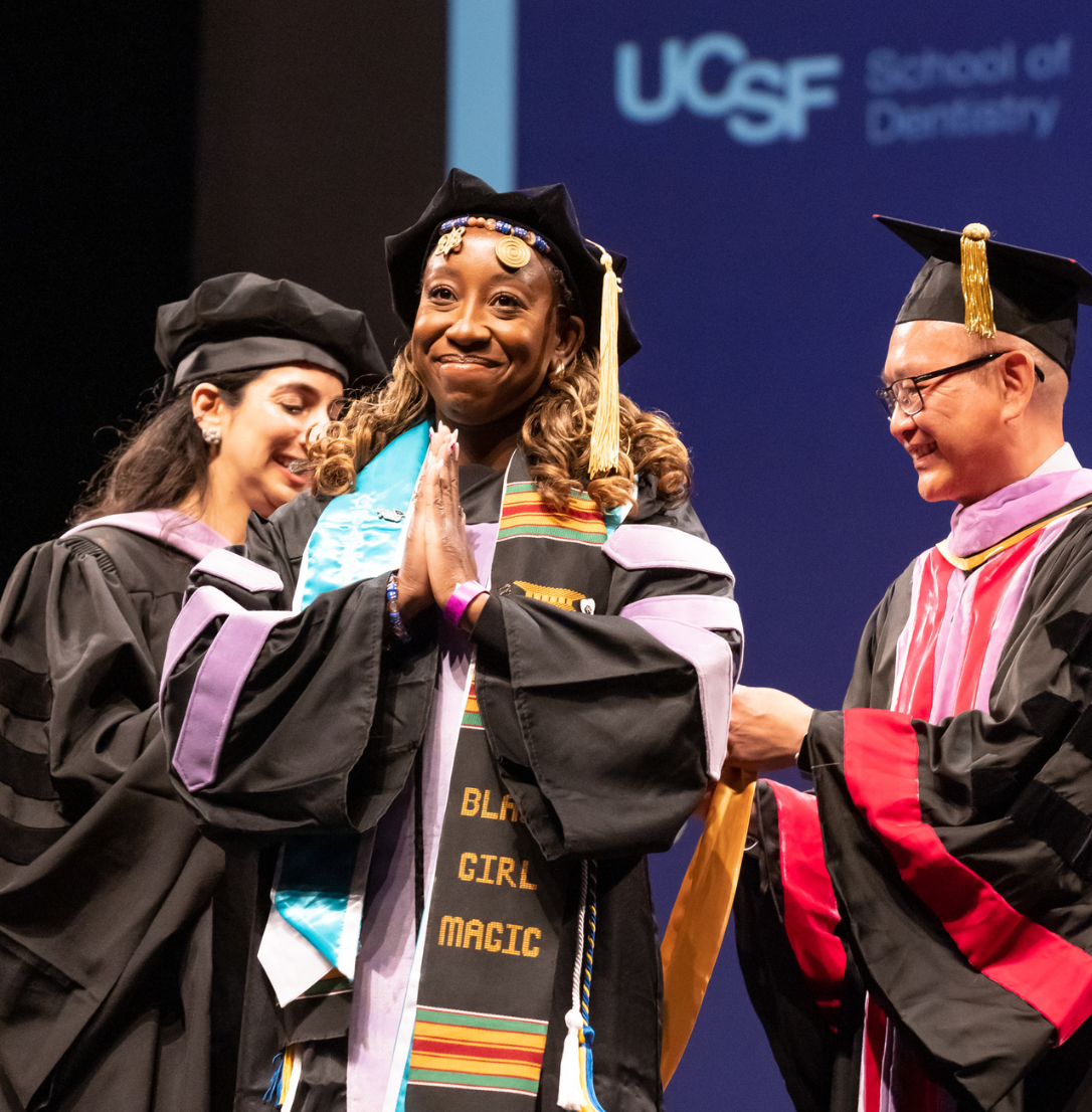 School of dentistry graduate smiles after receiving her hood