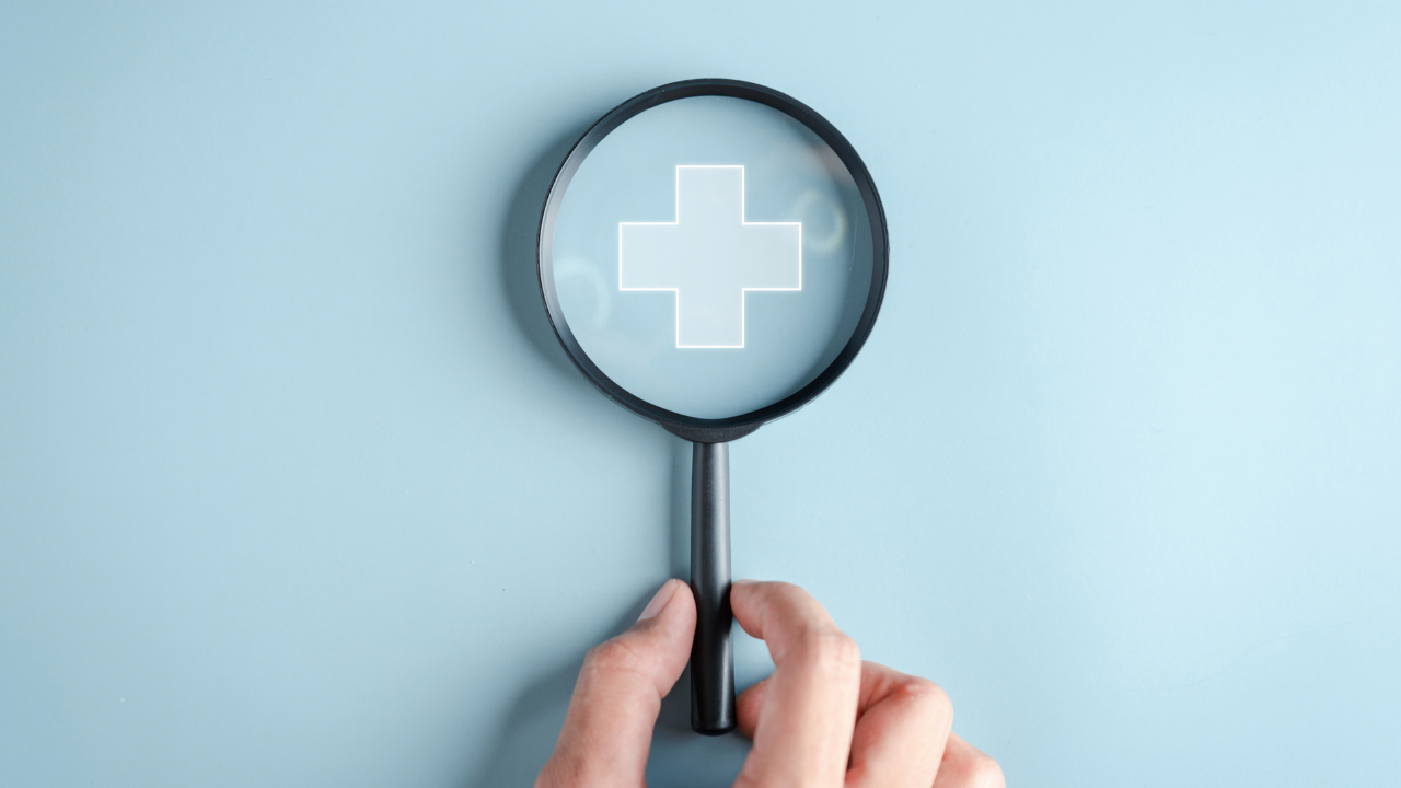 Image of magnifying glass with medical symbol