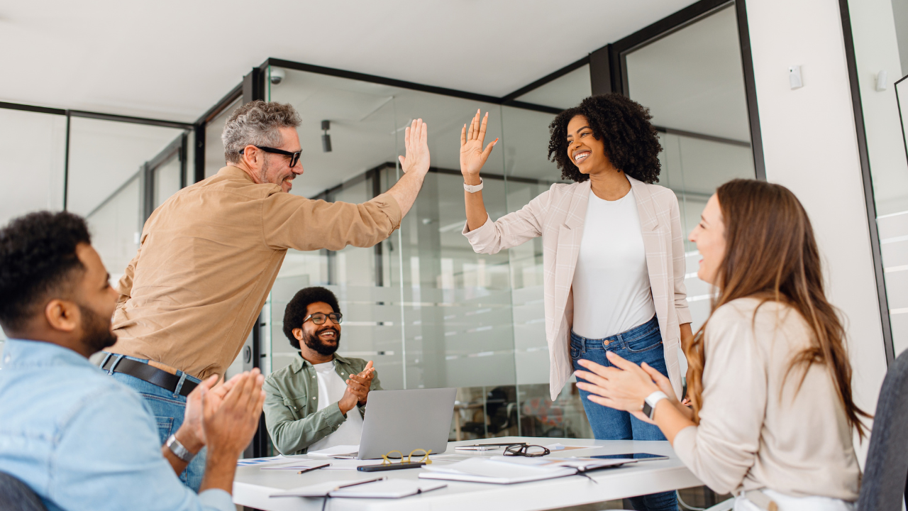 Colleagues in a work setting giving a high-five