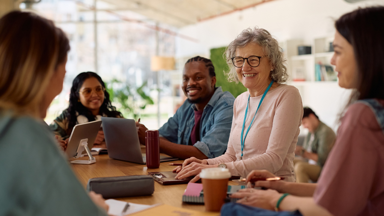 colleagues at a conference table laughing