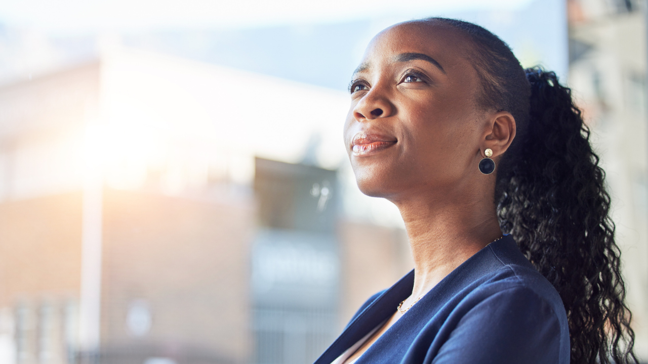 Professional Black woman looking into the distance in thought.