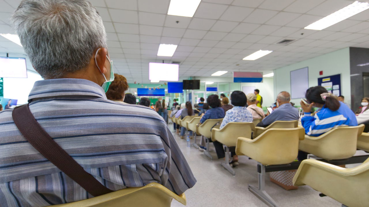 a full hospital waiting room with masked patients