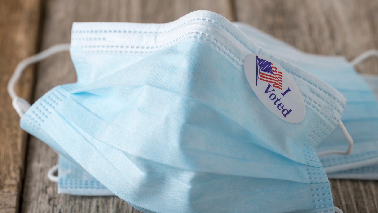 a medical facemask with an "I Voted" sticker on it