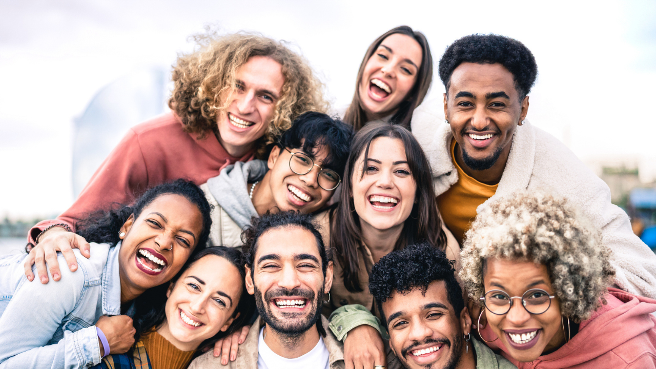 group of diverse adults huddle and smile for the camera