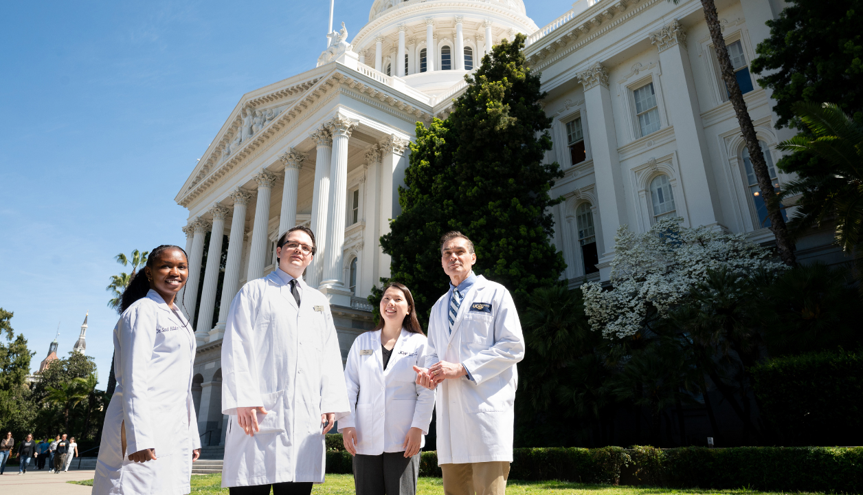 Students stand with Dean Reddy outside the capitol building in Sacramento