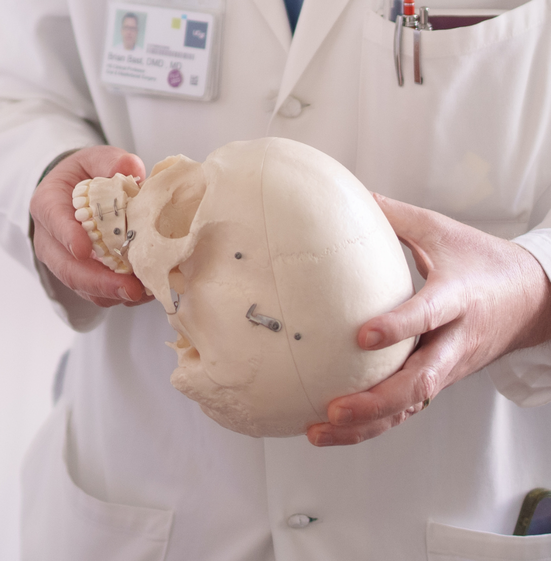 OMFS faculty member holds a scull model