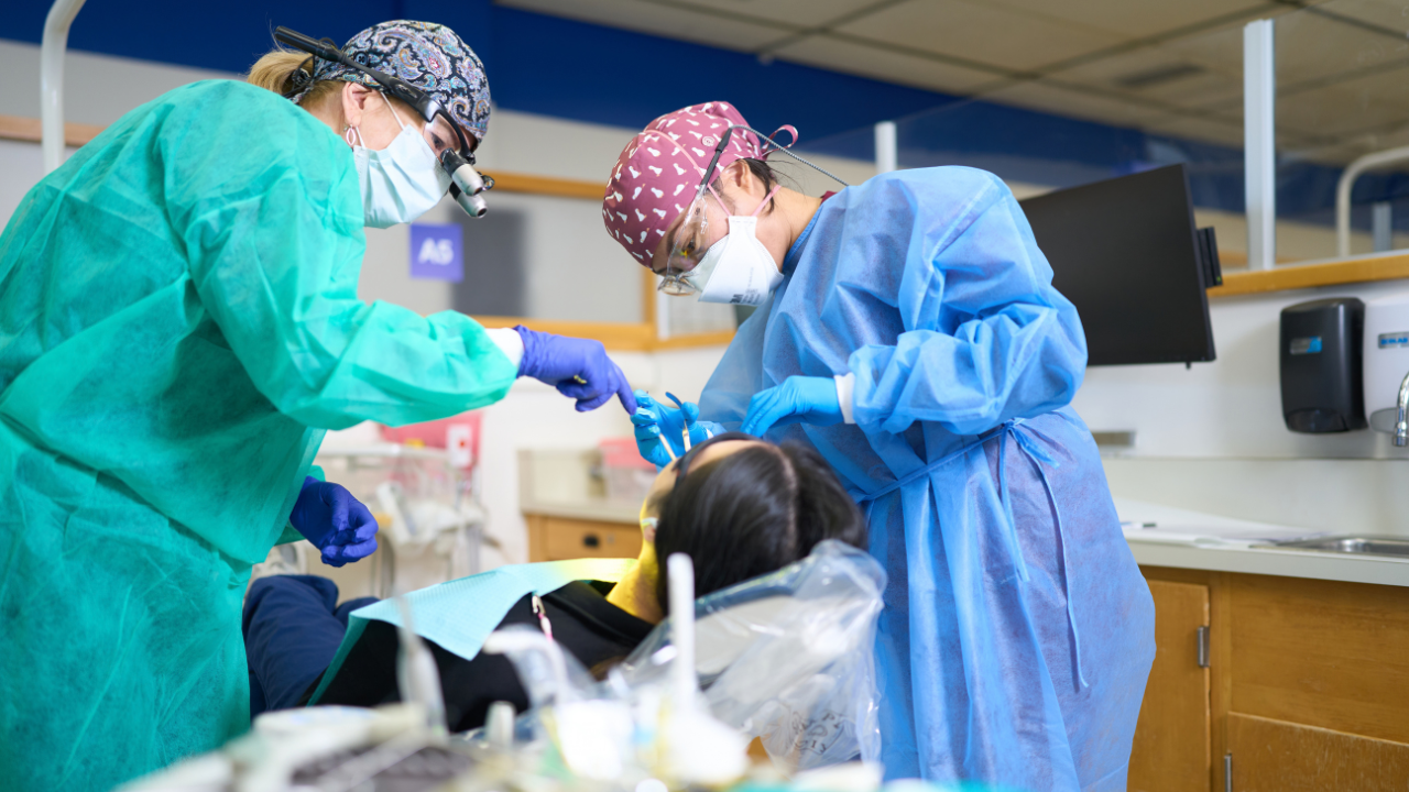 Dental student Hanna Tang (student patient, in chair), faculty member Melissa Tuft, DDS (left, in teal gown), student Bianca Romana (center) in the UCSF Student General Dentistry Clinic.