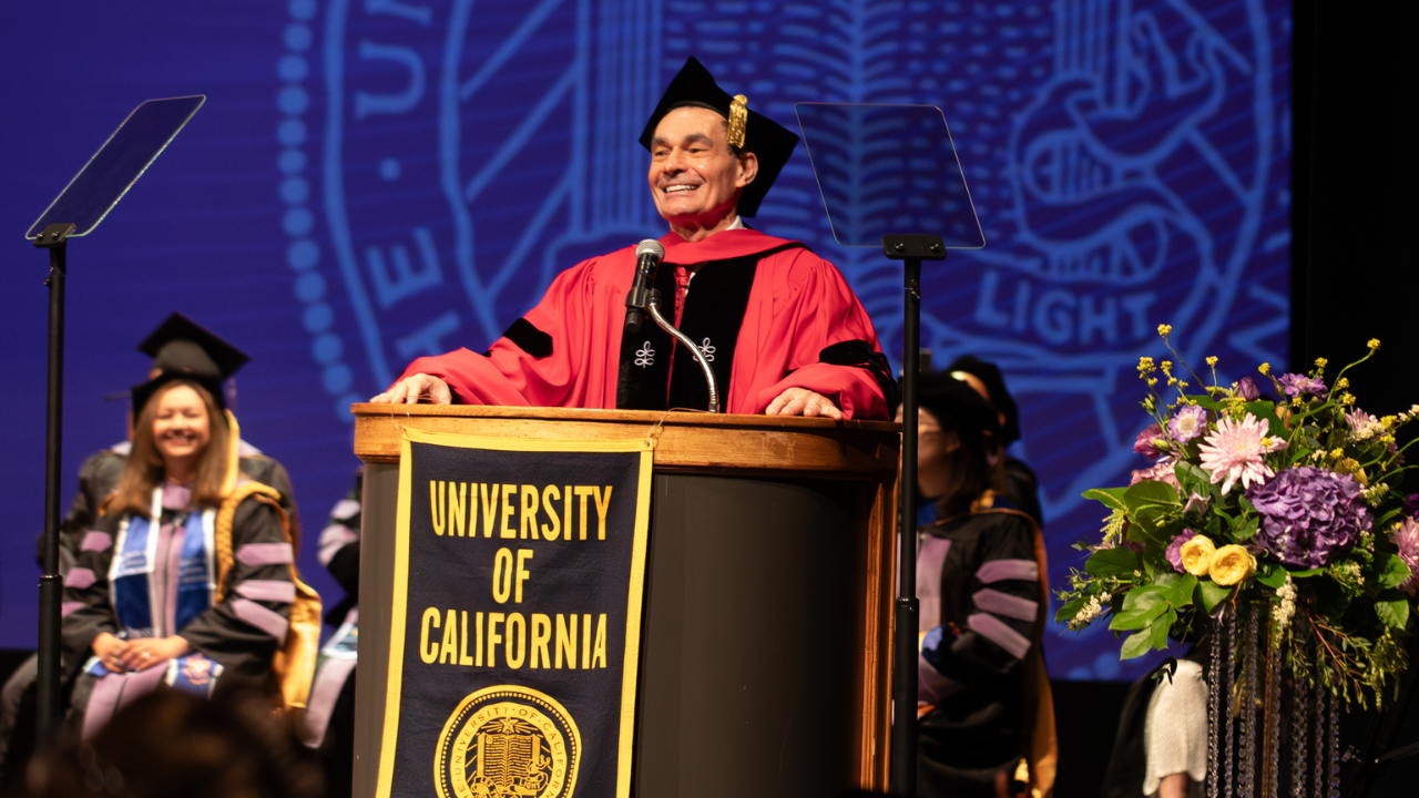 Dean Reddy at the podium welcoming the Class of 2026 and their friends and families