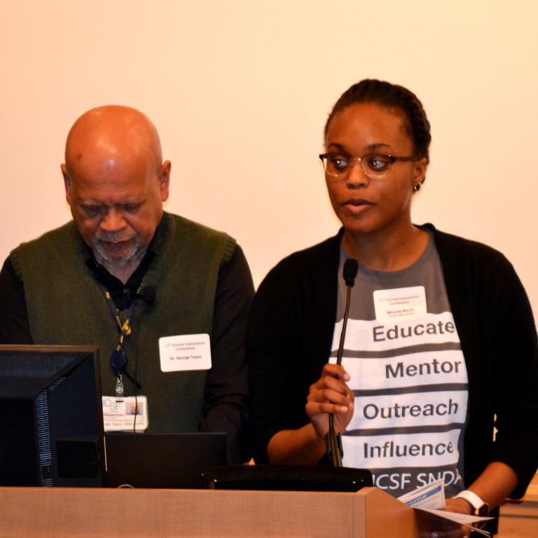 Mironda Frankenberger addresses the Impressions audience. At left, Dr. George Taylor, associate dean for diversity and inclusion in the School of Dentistry.