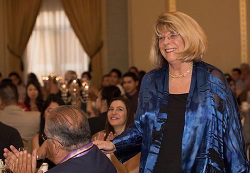 Medal of Honor recipient Susan Lopez '72 passes husband Michael Lopez '74 on her way to the podium.