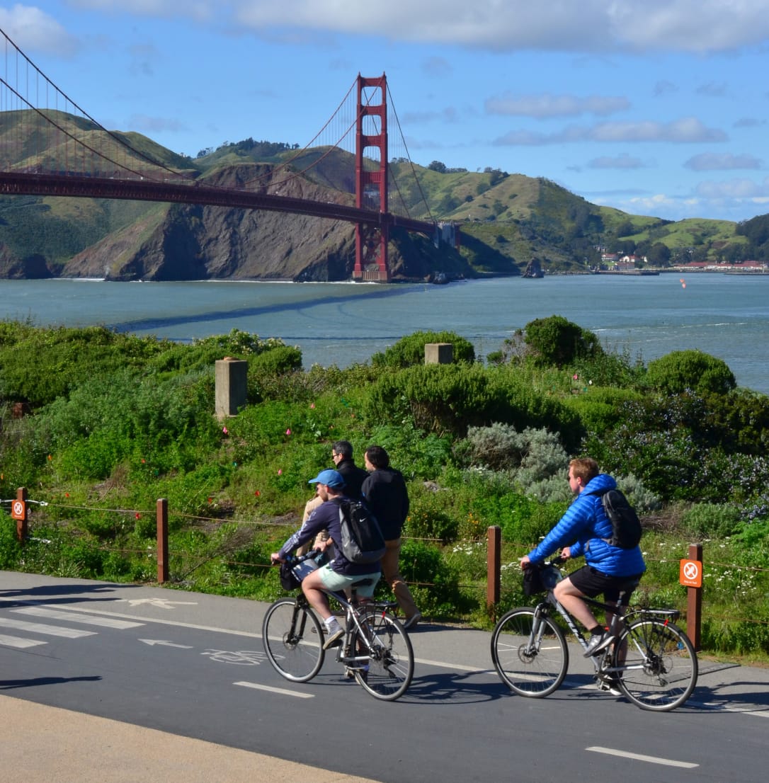 Two people riding bikes near the Golden Gate Bridge. 