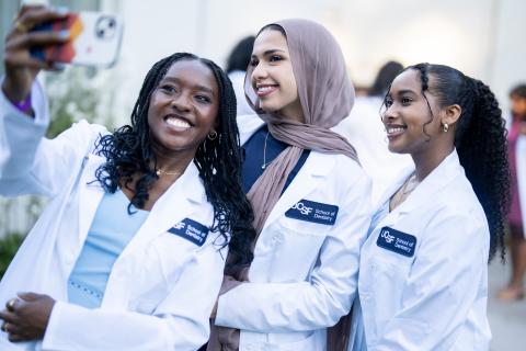 students take selfie outside presidio theatre before white coat ceremony 2024