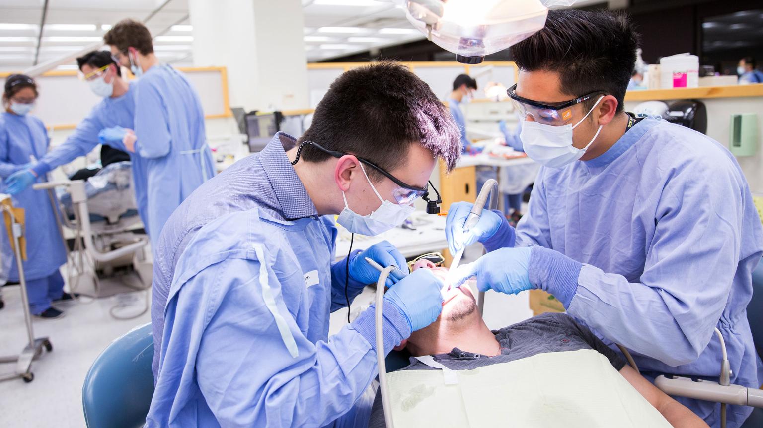 student dentists treat patient