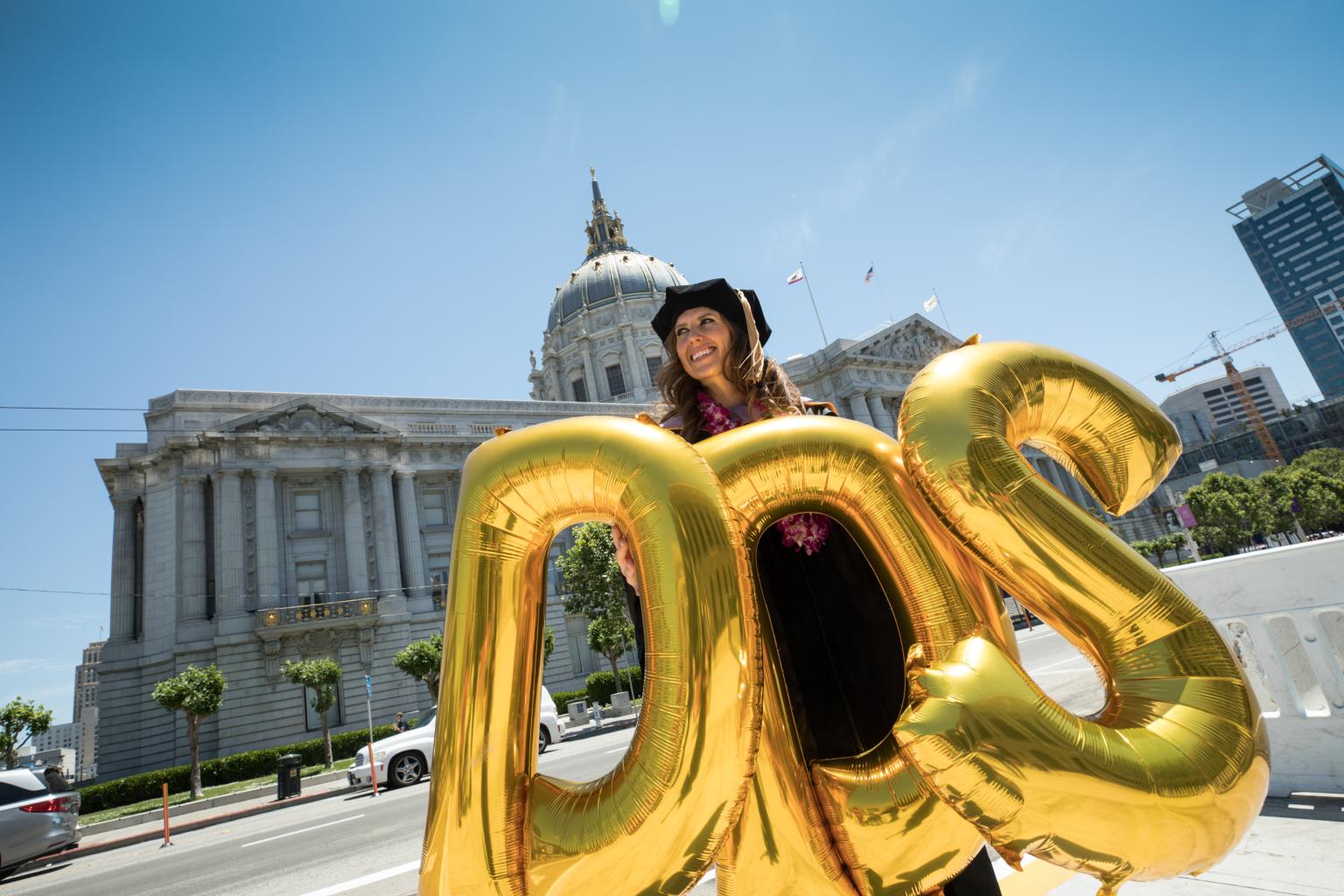 UCSF Dentistry graduate holding balloons