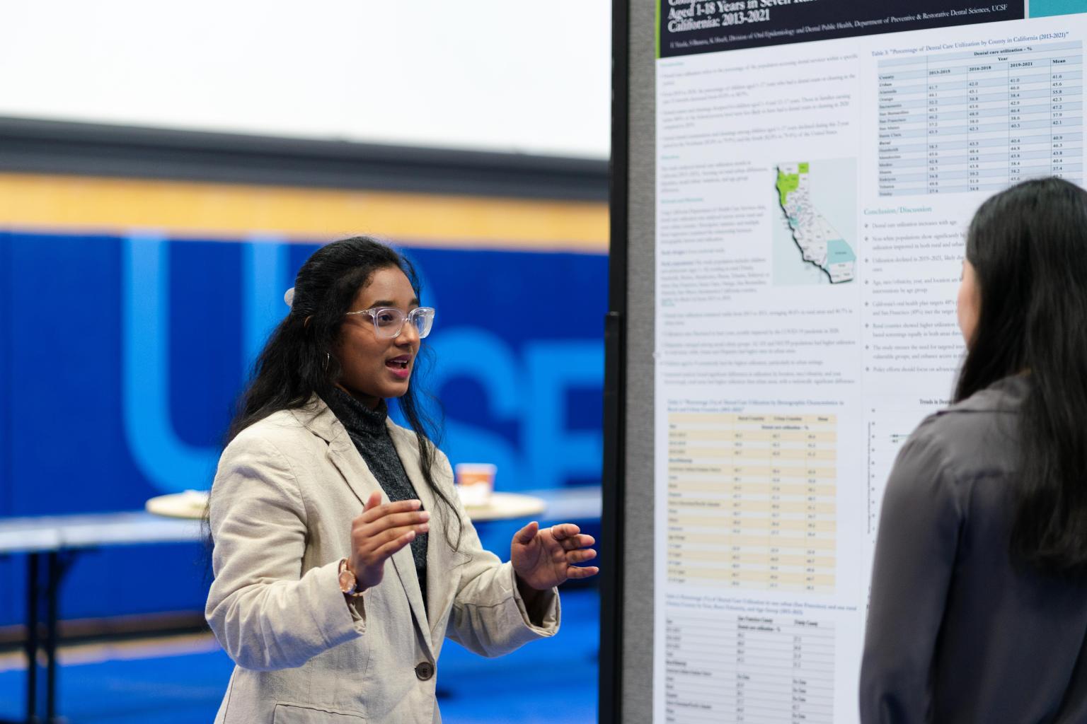 Image shows student presenting poster board at poster session of research and clinical excellence day