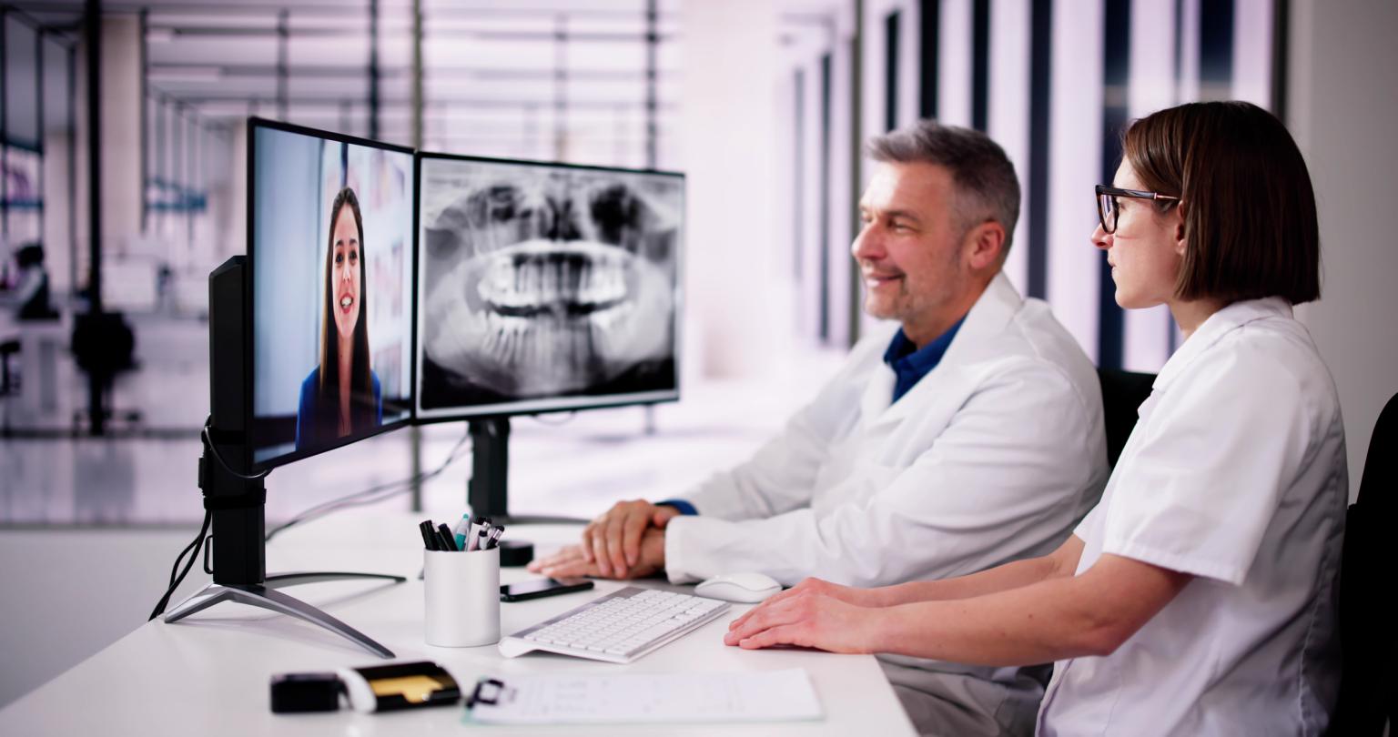 two healthcare providers in teledentistry visit with patient